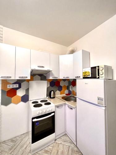 una cucina bianca con piano cottura e frigorifero di Parus Smart a Lviv