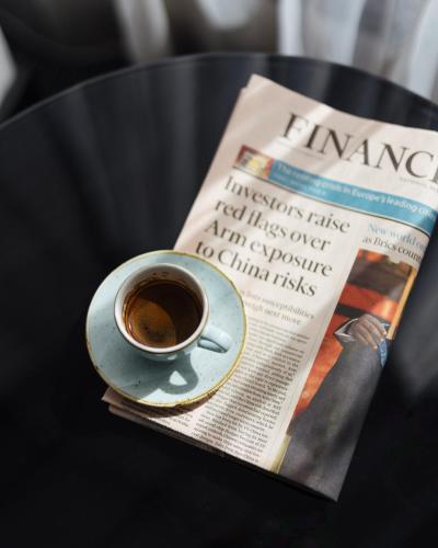 a cup of coffee sitting next to a newspaper at Montcalm Royal London House, London City in London
