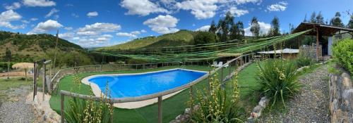 una hamaca alrededor de una piscina en un jardín en Cabaña Don Pepe, en Estancia Don Domingo en Curicó