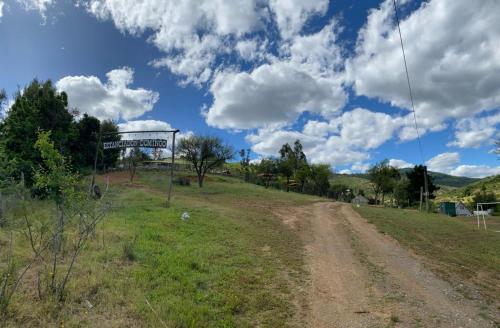 a dirt road with a sign on the side of a field at Estancia Don Domingo in Hualañé