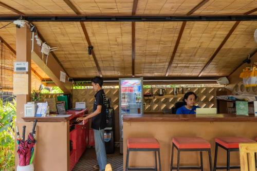 Jepun BnB Bali في سمينياك: شخصين واقفين عند كاونتر مطعم