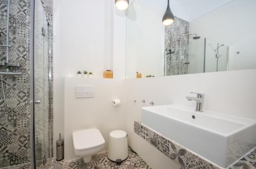 a bathroom with a sink and a toilet and a mirror at InPoint Cracow Apartments - Near Main Market Square in Krakow