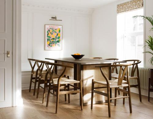 a dining room with a wooden table and chairs at Lux Mews House Portobello 4 bed in London