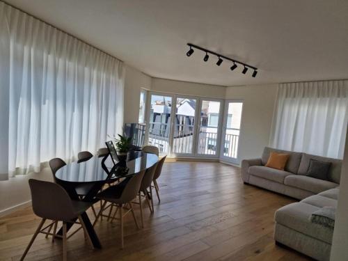 sala de estar con mesa, sillas y sofá en Luxury Renovated 3 Rooms Apartment en Ostende