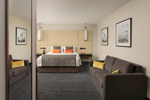 a living room with a bed and a couch at Montcalm Royal London House, London City in London