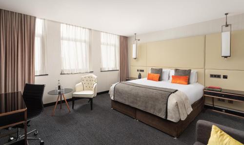 a hotel room with a bed and a table and chairs at Montcalm Royal London House, London City in London