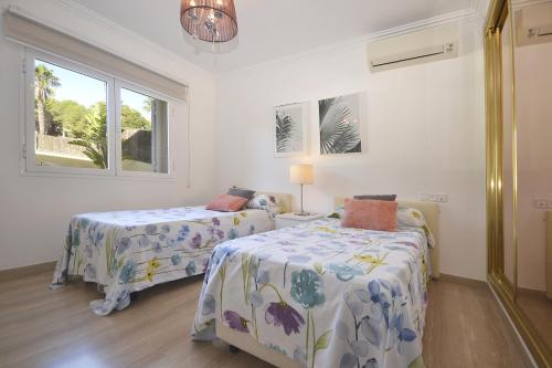 a bedroom with two beds and a window at Villa Prestige in Can Picafort