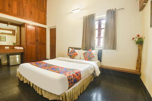 a bedroom with a large bed with a window at FabHotel Royal Baga Residency in Old Goa