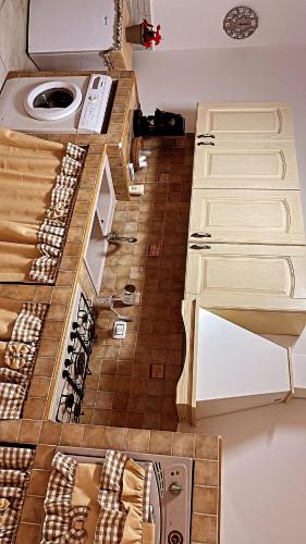 Il comprend une cuisine avec des placards blancs et du parquet. dans l'établissement the cousins' house, à Palerme