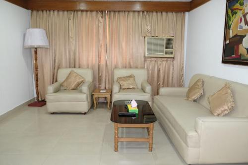 Sala de estar con 2 sofás y mesa en Hotel Saint Martin Ltd., en Chittagong