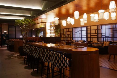 a restaurant with wooden tables and chairs and chandeliers at Hotel Star City in Chennai