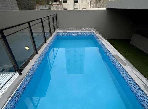 una piscina de agua azul en un edificio en Nuevo, Bellísimo, Confort y muy amplio - 2 Dormitorios, uno en Suite - 2 baños y Pileta !! en Rosario