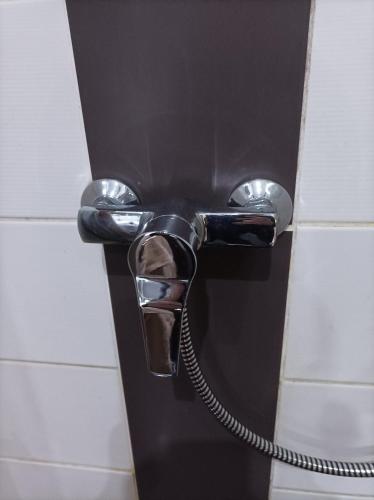 a hose hooked up to a toilet paper dispenser on a wall at Fitness Pension in Sulingen