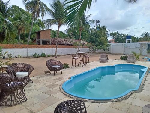 einen Pool auf einer Terrasse mit Stühlen und einem Tisch in der Unterkunft POUSADA PARAISO DO GAUCHO in Córrego das Panelas