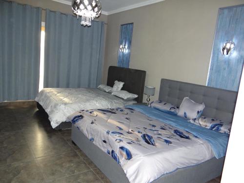 1 dormitorio con 2 camas y lámpara de araña en Huge Entire apartment for Couples ,families & Groups -up to 5 Guests- with free pool, steam & Sauna ,JVC,Dubai, en Dubái