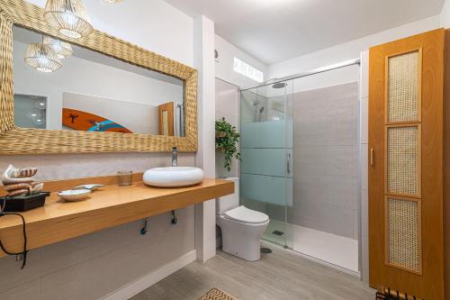 uma casa de banho com um lavatório, um WC e um espelho. em Brisa Marina em La Jaca