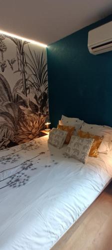 une chambre avec un grand lit avec un mur bleu dans l'établissement Appartement cosy à deux pas du port, à Saint-Cyprien