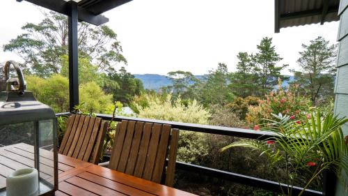 a balcony with two chairs and a view of the mountains at Mike's Kangaroo Valley in Kangaroo Valley