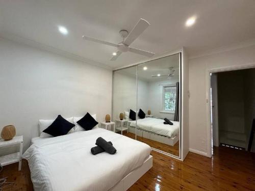 Habitación blanca con 2 camas y espejo. en 2 Bedroom Darling Harbour - Pyrmont 2 E-Bikes Included, en Sídney