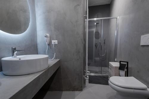 La salle de bains est pourvue d'un lavabo, d'une douche et de toilettes. dans l'établissement B&B Maison Azzurra Malpensa, à Turbigo