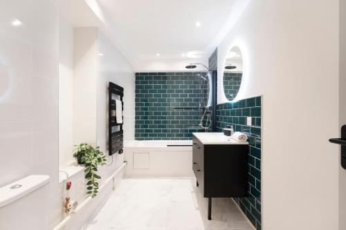 La salle de bains est pourvue de carrelage vert du métro et d'un lavabo. dans l'établissement Sur la Seille, à Metz