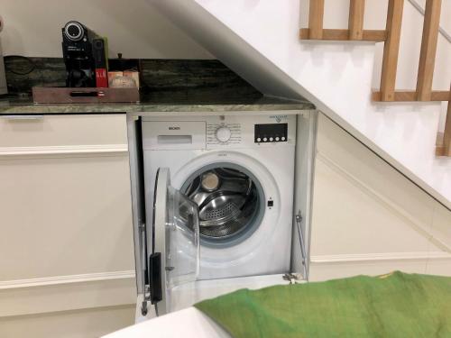 a washer and dryer in a room under a staircase at Pool oasis with private parking -Vigia 8 in Torres Vedras
