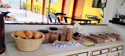a counter with bread and other food items on it at Hospedagem Encantos da Serra in Itatiaia