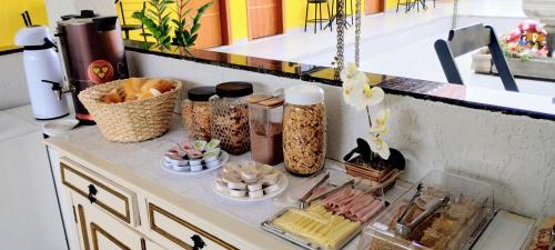 a counter with various food items on top of it at Hospedagem Encantos da Serra in Itatiaia