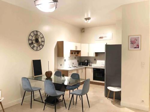 ein Zimmer mit Tisch und Stühlen und eine Küche in der Unterkunft LE MANOIR - REZ DE CHAUSSEE - PARKING - WIFI - CENTRE VILLE in Quimper