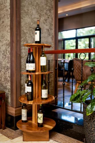 a bunch of wine bottles on a wooden shelf at Athena Hotel Kampala in Kampala