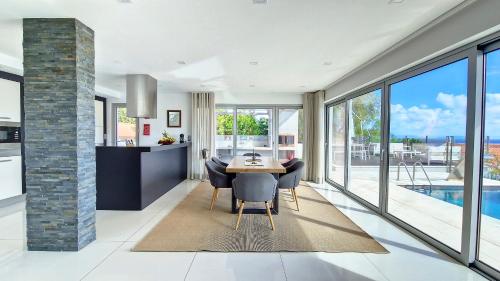 a kitchen and dining room with a table and chairs at Villa Madeira by LovelyStay in Caniço