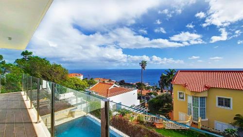 a view from the balcony of a house with a swimming pool at Villa Madeira by LovelyStay in Caniço
