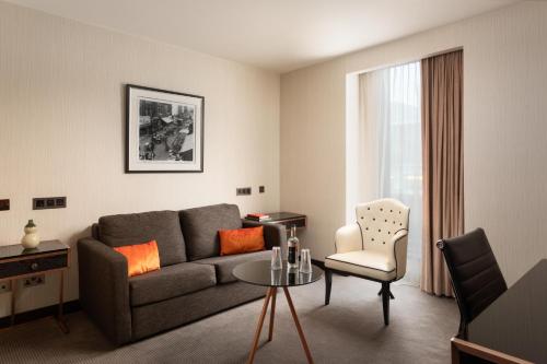 a living room with a couch and a table and a chair at Montcalm Royal London House, London City in London