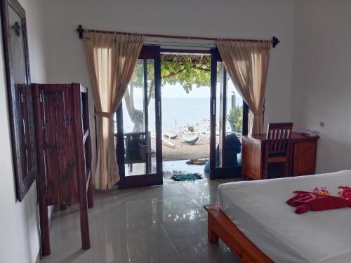 Schlafzimmer mit einem Bett und Strandblick in der Unterkunft Kumpul Beach in Amed