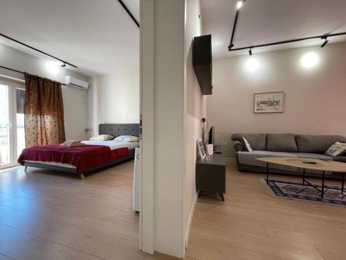 - un salon avec un lit et un canapé dans l'établissement DownTown View Modern Apartment, à Tirana