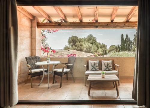 a patio with a table and chairs and a window at Finca Es Torrent in Campos