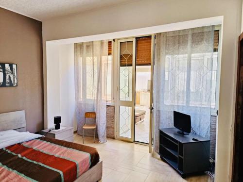 パレルモにあるGaia Apartmentのベッドルーム(ベッド1台、テレビ、窓付)