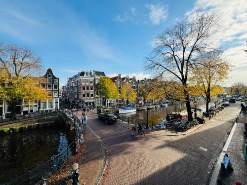 una calle de la ciudad con un río y edificios y árboles en Décor Canal House, en Ámsterdam