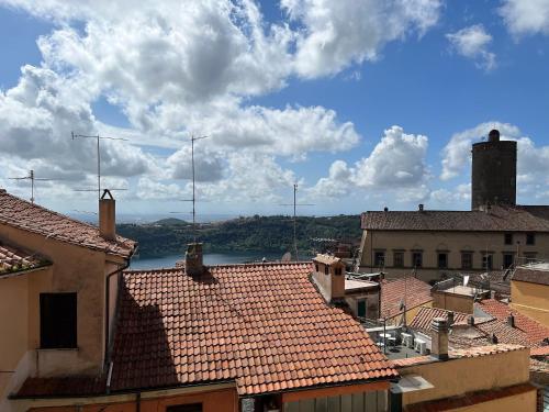 - une vue sur une ville avec des toits et une masse d'eau dans l'établissement Albergo Diffuso Locanda Specchio Di Diana, à Nemi