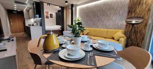 a table with cups and saucers on it in a living room at Apartamenty IMPRESSA BASEN - SPA - SAUNA Lublin Centrum in Lublin