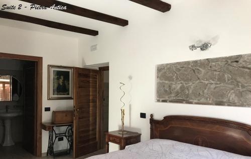 a bedroom with a bed and a stone wall at Albergo Diffuso Locanda Specchio Di Diana in Nemi