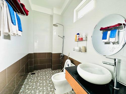 a bathroom with a sink and a mirror and a toilet at Co Bon Beachside in Hoi An