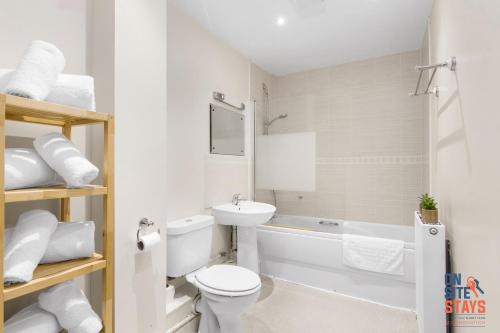 ein weißes Bad mit einem WC und einem Waschbecken in der Unterkunft OnSiteStays - Cosy 2-Bedroom Apartment with Free Parking, Wi-Fi & London Links in Northfleet