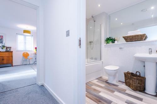 a white bathroom with a sink and a toilet at Chester City Apartment in Chester