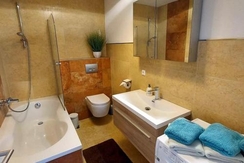 a bathroom with a sink and a tub and a toilet at Ferienwohnung und Zimmer zum Donaublick in Kelheim