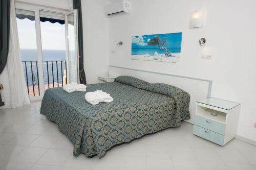 a bedroom with a bed and a view of the ocean at Hotel Weber Ambassador in Capri