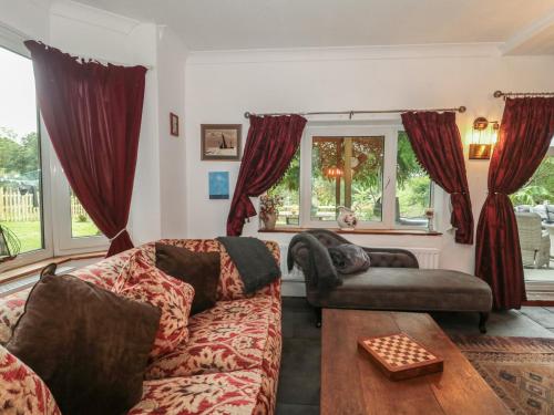 una sala de estar con un sofá y una silla en Brook Farm, en Ringwood