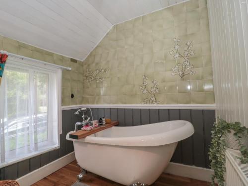 baño con bañera blanca y ventana en Brook Farm, en Ringwood