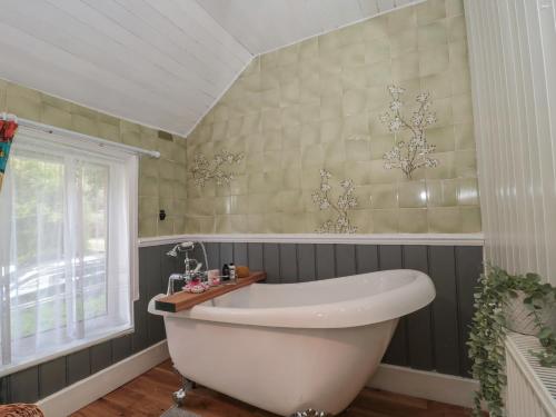 a bathroom with a white tub and a window at Brook Farm in Ringwood