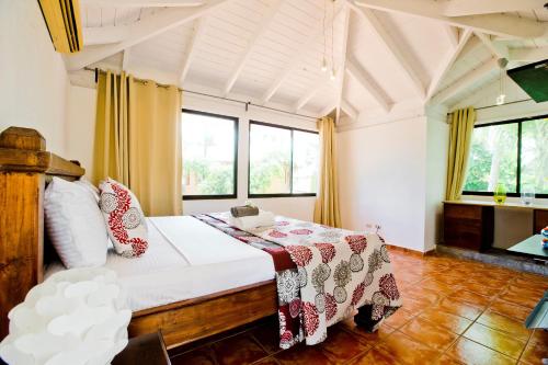 ein Schlafzimmer mit einem Bett in einem Zimmer mit Fenstern in der Unterkunft Cozy 3-Bedroom Apartment with Pool Access near Bavaro Beach in Punta Cana